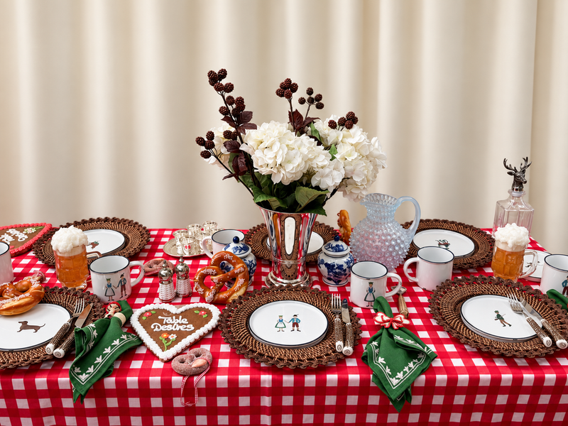 Festlich gedeckte bayerische Wiesn-Tafel mit roter Vichy-Tischdecke, handbemaltem Porzellan, Hornbesteck und versilberter Blumenvase von Table Desires