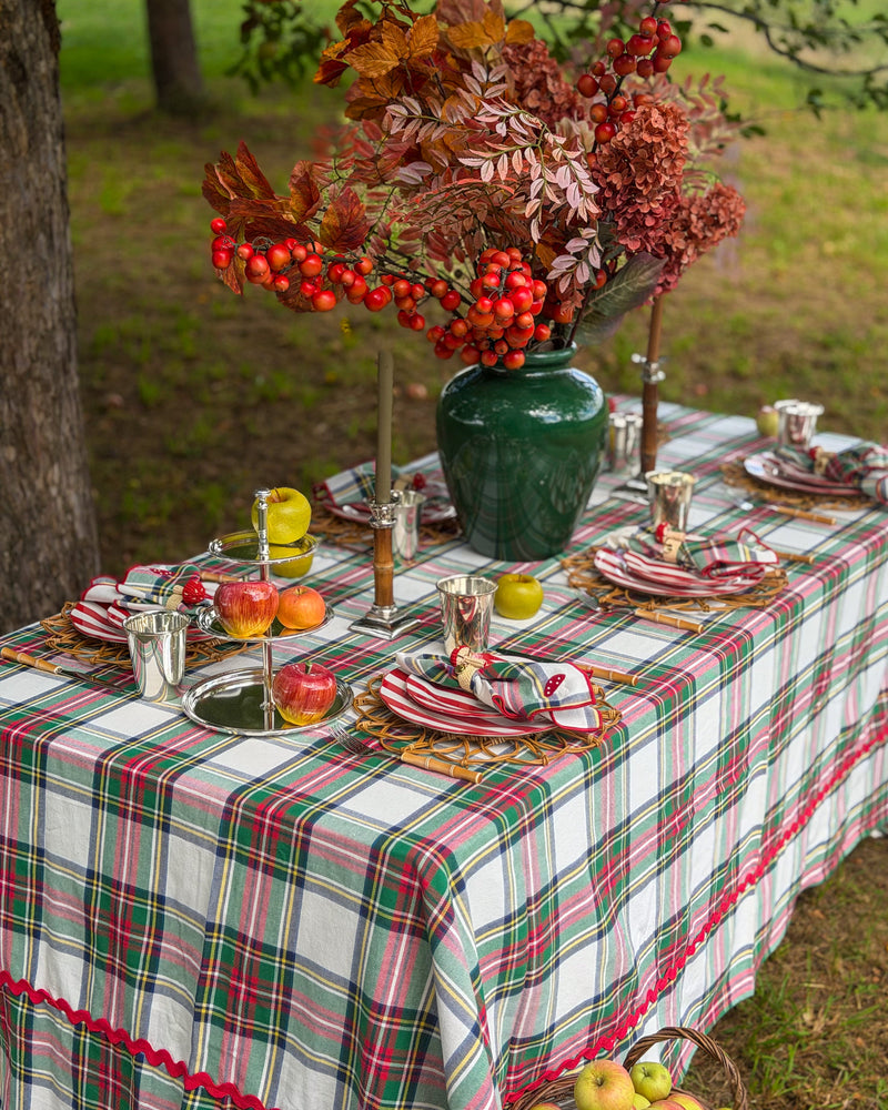 Idyllisch gedeckte Erntedank-Tafel unter einem blühenden Apfelbaum mit klassischer Tartan-Tischdecke, handbemaltem Porzellan mit Apfelmotiven und edel versilberten Tisch-Accessoires von Table Desires